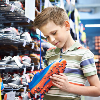 Boy with soccer shoes in the sports store