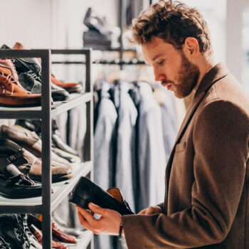Young handsome man choosing shoes at a shop